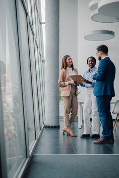 Business people discussing work in modern office building hallway