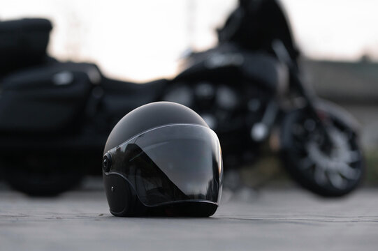 A stylish black motorcycle helmet is showcased in the foreground with a blurred motorcycle in the background, perfect for capturing the essence of adventure and safety.