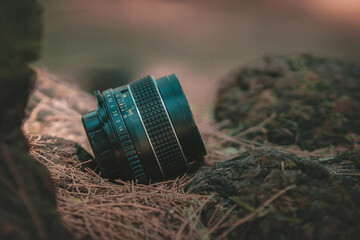 Antique Camera Lens on the grass of a beautiful forest, copy space, concept of the world day of photography.