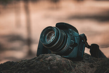 Digital camera with an antique lens on the lawn of a beautiful forest, world photography day concept, copy space.