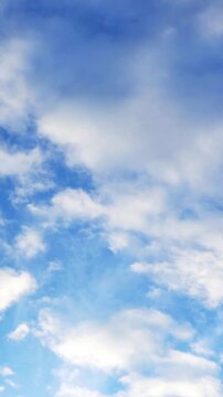 Clouds flying on blue sky background. Vertical footage