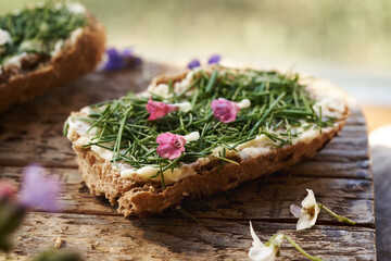 Spring wild edible plant called onion grass or crow garlic on a slice of bread