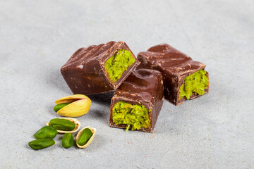 Modern dessert. Dubai chocolate bar with crispy kataifi and pistachio paste. White background. Close up
