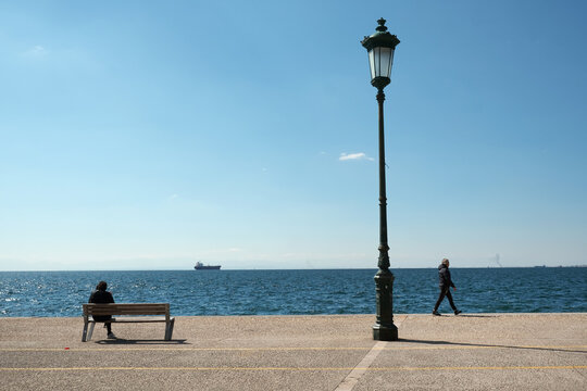 People relaxing on the Nea Paralia - Seaside Promenade in Thessaloniki, Greece. 