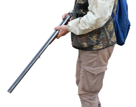 Mature hunter man holding a shotgun and walking through a field