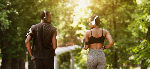 Rear View Of African American Couple Jogging Outdoors In Morning Park, Running On Path Together And...