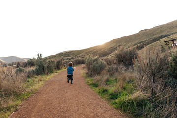 A young toddler plays with a bubble gun outside while camping.