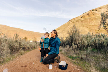 A young toddler enjoys a camping trip with his mother in Oregon.