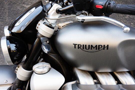 Close up of a motorbike tank with Triumph branding and controls