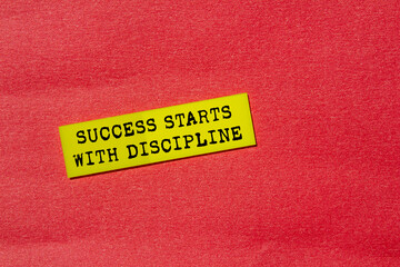 Success starts with discipline message written on yellow paper label on red background. Conceptual...