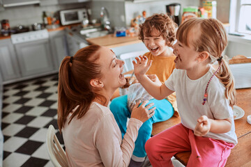 Single mother having breakfast with her two kids in the kitchen