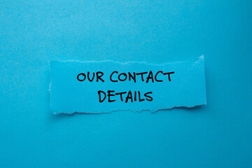 Our contact details message written on ripped torn paper piece on blue background. Conceptual our contact details symbol. Copy space.