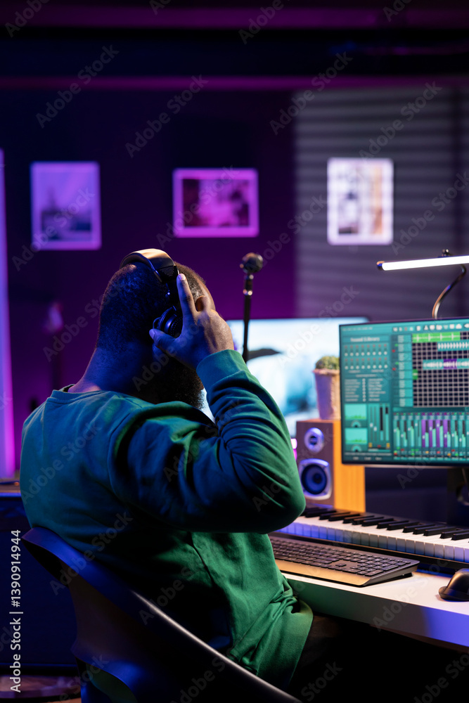 Poster Musician playing piano keys and editing to improve the sound quality of audio recordings in his home studio, putting on headset. Music producer uses midi controller to manipulate sounds.