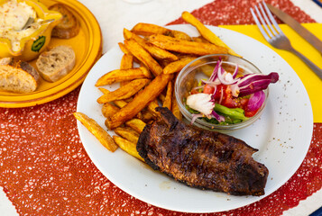 Tasty baked duck breast with potatoes served with vegetable salad and sause