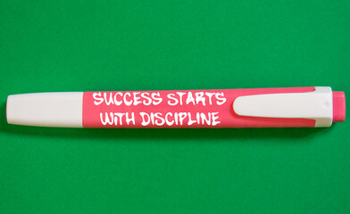 Success starts with discipline message written on pink marker pen on green background. Conceptual...