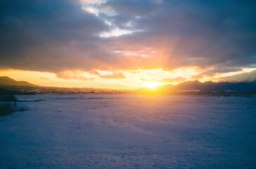 sunset over snowy landscape in winter 