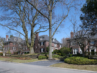 Residential neighborhood with large brick detached houses and mature trees