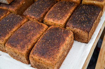 Freshly baked artisan bread loaves topped with aromatic herbs displayed on table, showcasing traditional baking methods and emphasizing natural ingredients, health consciousness, and homemade quality