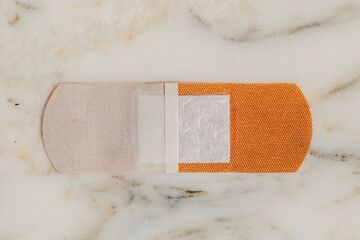 underside of flexible fabric adhesive bandage on bathroom counter