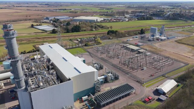 An industrial power station with twin chimneys stands next to the Lincolnshire Canal, UK