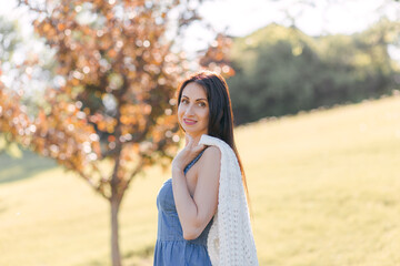 A young pretty woman is walking on the green grass. Sunny summer day outdoors