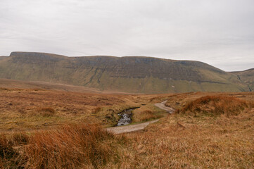 Obraz premium A dry, barren field with a small stream running through it