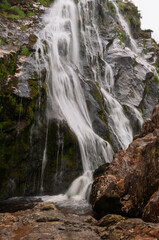 A waterfall is flowing down a rocky cliff