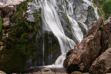Obraz premium A waterfall is flowing down a rocky cliff