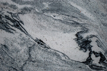 Smooth marble surface displays striking black and white patterns with intricate veins, creating a visually appealing texture and design