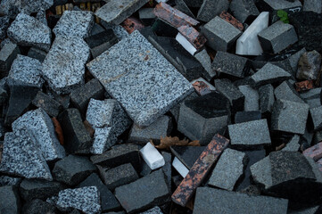 Different types of stones and bricks are scattered on the ground in a construction zone during the...