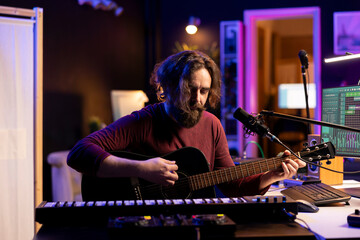 Musician with condenser microphone creating a song on guitar, working on mixing and mastering...