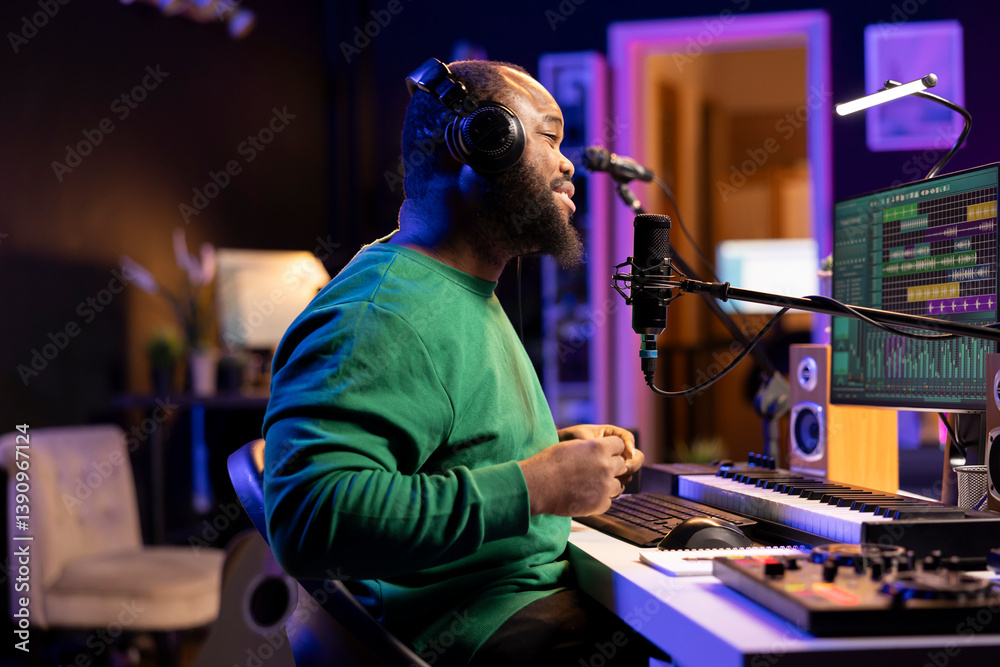 Aufkleber Young producer performing a live acoustic song in home studio, recording a new track on microphone and using DAW software. Artist songwriter editing the audio files in post production.