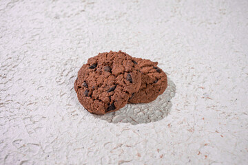 Cracked Chocolate Cookies On A Rough White Background, Showing Rustic Charm And Homemade Cookie Goodness.
