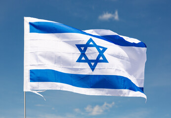 Huge flag of Israel attached on long handle against background of clear bright sky