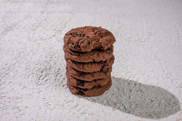 Perfectly Stacked Chocolate Cookies On A White Texture, Showcasing A Classic Homemade Treat With Simple Yet Inviting Presentation.