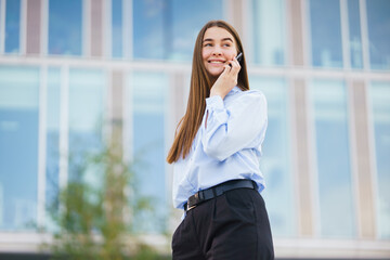 Fototapeta premium Young Professional Engaged in a Conversation Outside a Modern Building During a Bright Day