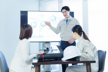 会議室でプレゼンをする技術者