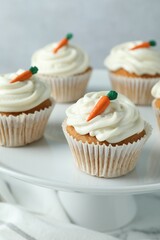 Delicious carrot cupcakes on table against grey background, closeup