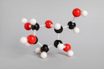 Molecule of glucose on light grey background. Chemical model