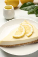 Piece of delicious lemon cheesecake on white table, closeup