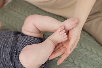 Mother and her cute little baby on bed, closeup