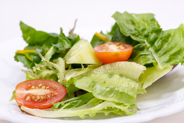 Salad with spinach, cherry tomatoes, lettuce, cucumber and many more vegetables isolated