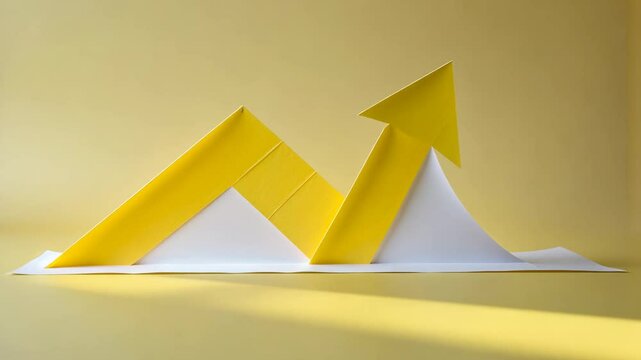Yellow paper cut-out of a right-up arrow bent upwards on one side with a white backing showing the direction of growth.