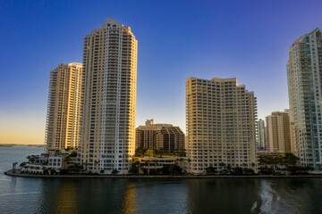 Fototapeta premium Skyscrapers dominate the skyline in Miami, Florida, USA. The buildings are located on the waterfront, reflecting in the water. The photo showcases urban development.