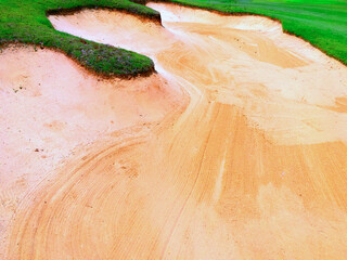 Golf course sand bunker with textured surface and bright natural lighting