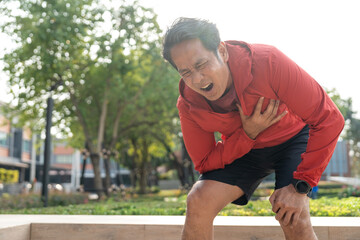 Senior asian man tired during jogging at outdoor nature park. Mature asian male intense training workout challenge breathing exhausted. Healthy and activity lifestyle concept.