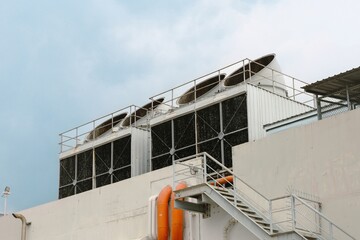 Large rooftop HVAC cooling towers with ventilation fans and piping, used for climate control in commercial or industrial buildings.
