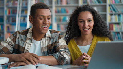 Two students African American man Hispanic Arabian woman together project teamwork discuss talking...