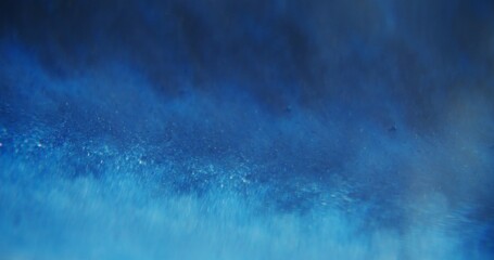 Blue swell. Defocused sparkling water. Shimmering blinking viscous paint liquid motion on blurred bokeh light abstract modern background.