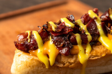A hot dog topped with smoked beef and drizzled with honey mustard sauce, closed up
